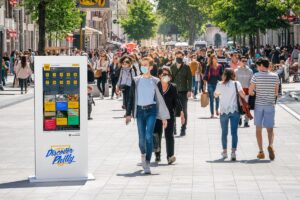 people walking next to a touch kiosk