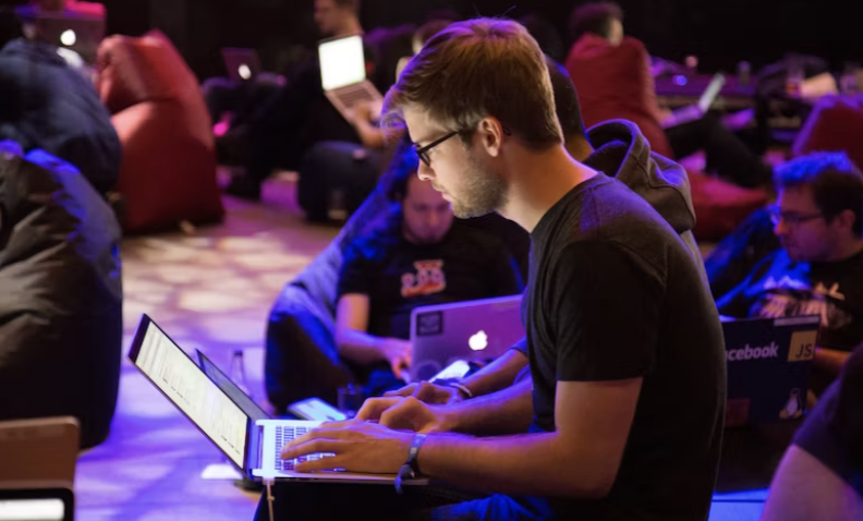 a person typing on a computer at a conference