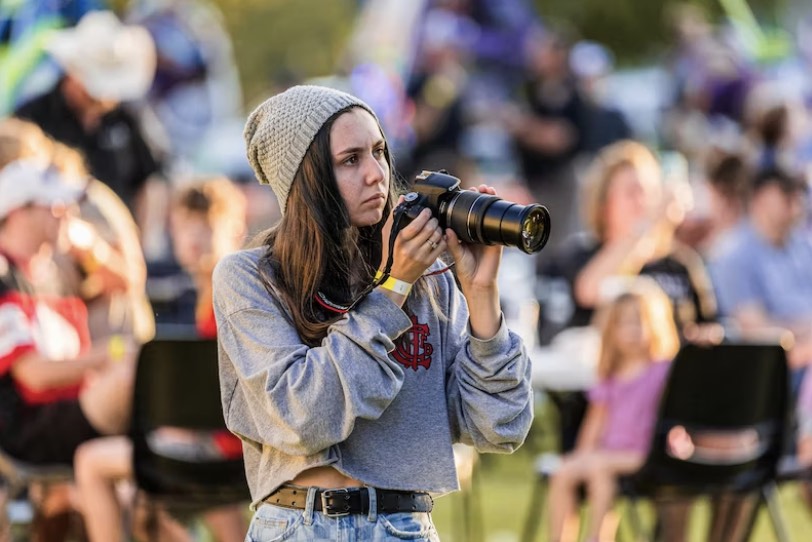 a young adult holding a camera